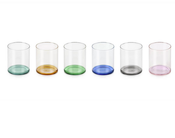 The Fondale Tumbler Set of 6 - Assorted by Ichendorf Milano features hand-blown glass tumblers, each with a differently colored borosilicate glass base—green, amber, light green, blue, gray, and pink—arranged in a row.