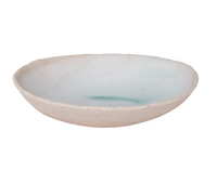 A shallow, round stoneware bowl by Jars, the Wabi Dinnerware Vert features a rough beige exterior and a smooth blue-green glazed interior—a striking example of wabi-sabi aesthetics in modern dinnerware.