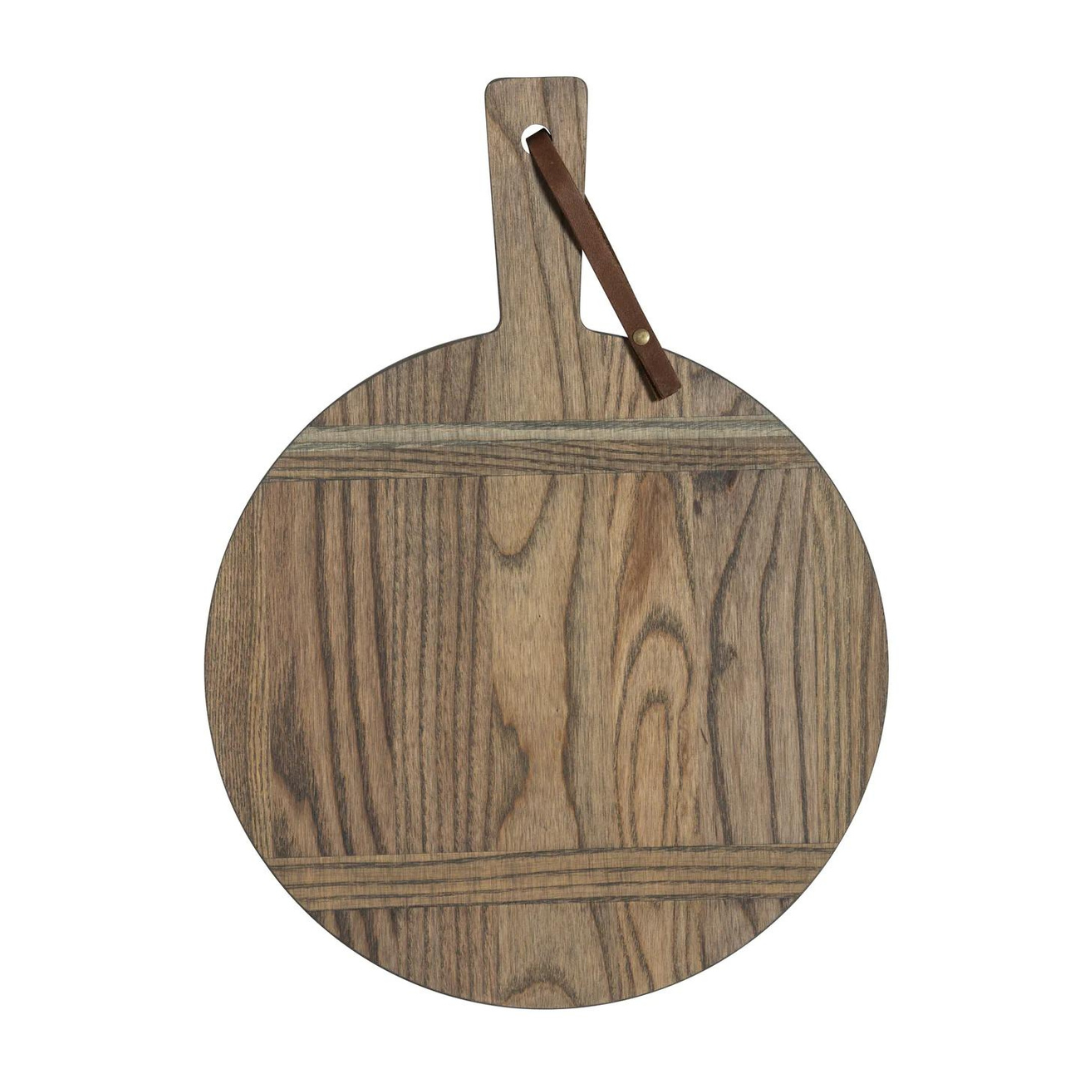 The JK Adams Ash Driftwood Round Serving Board features a handle with a brown leather loop and displays the natural grain of ash wood, highlighted by a stylish driftwood finish.