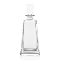The Zodax Kelsey Crystal Decanter, featuring a clear, geometric design with a square stopper and wide base, is the perfect addition to elevate your home bar or barware collection; shown here photographed against a white background.