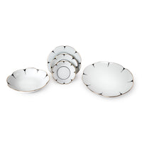 The Molecot Drops Dinnerware set features elegant white ceramic dishes with scalloped edges and gold trim, including two large bowls and three smaller plates stacked vertically.