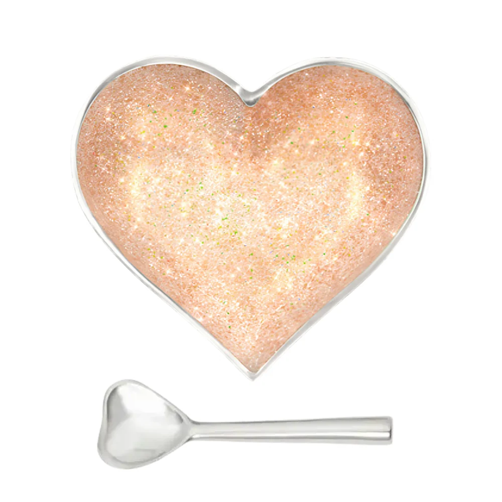 A heart-shaped Happy Heart Sparkle Gold Bowl With Spoon filled with gold glitter and accompanied by a matching heart-shaped spoon.