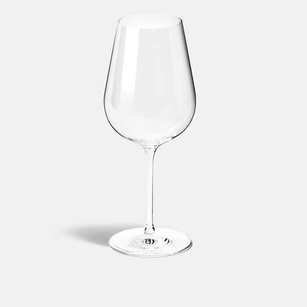 The Jancis Robinson Precision Wine Glass Set of 2 by Richard Brendon stands upright on a plain, light gray background, its long stem and wide bowl casting a faint shadow to the left.