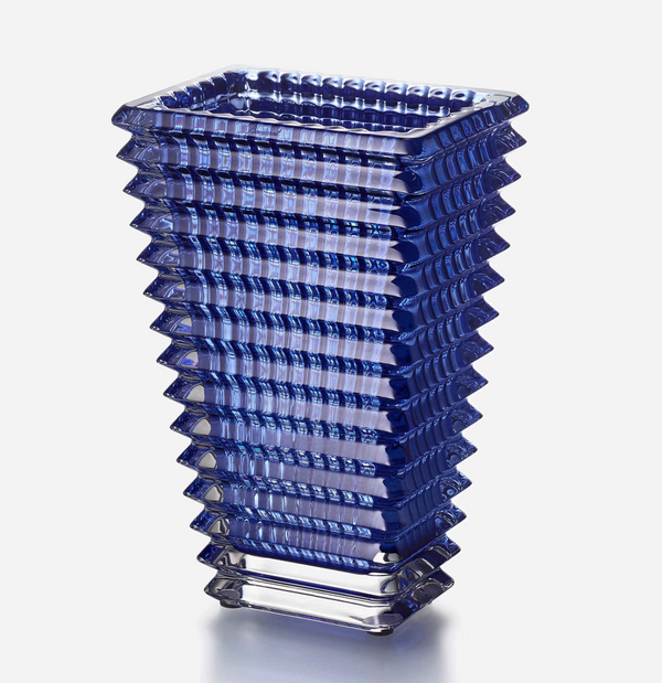The Eye Vase Rectangular Small - Blue by Baccarat features a tall, geometric blue glass design with a square base that widens at the top and stepped ridges for a modern, architectural look against a plain white background.