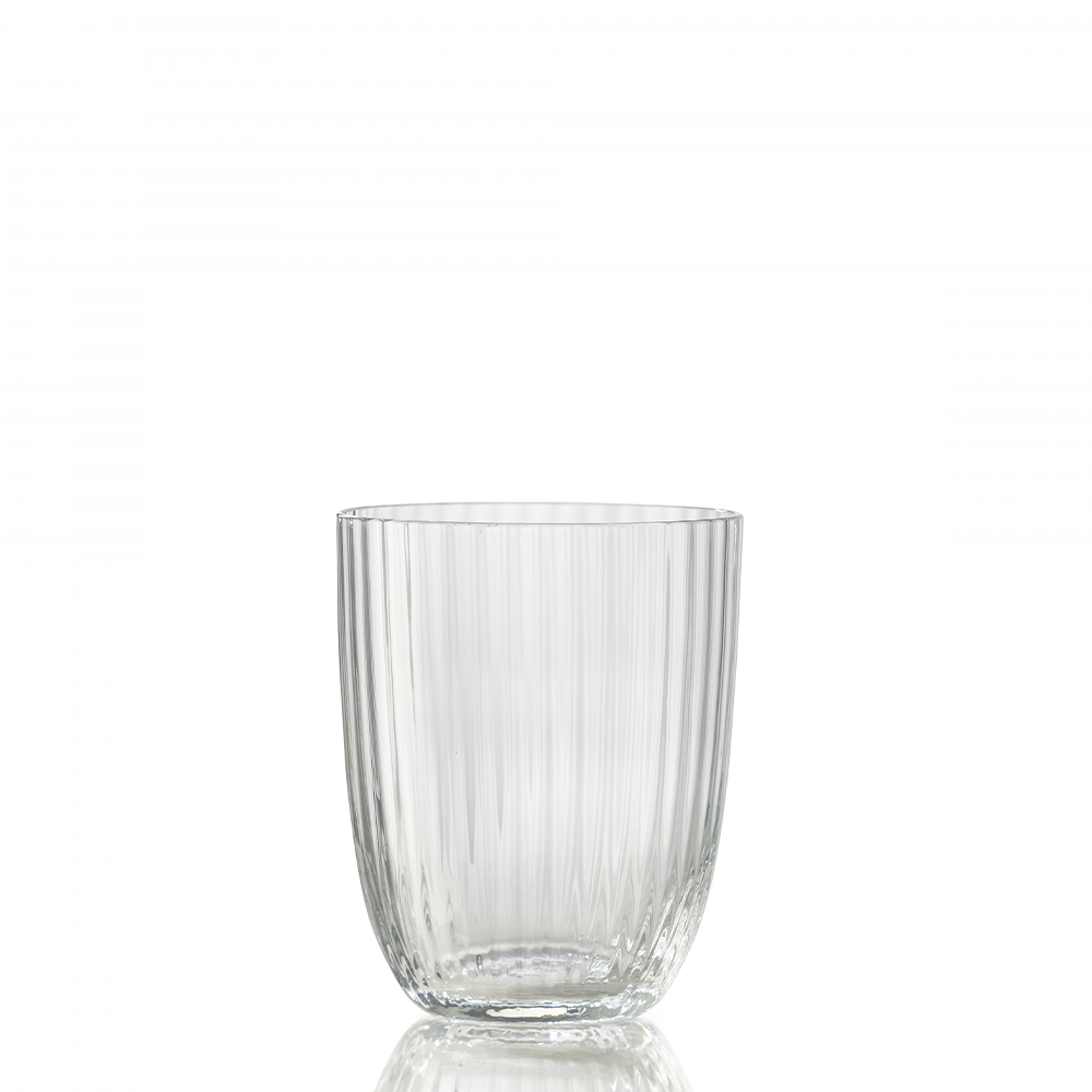 The Nason Moretti Idra Tumbler Rigadin is a clear glass with vertical ribbed lines, shown empty on a reflective surface and set against a plain white background.