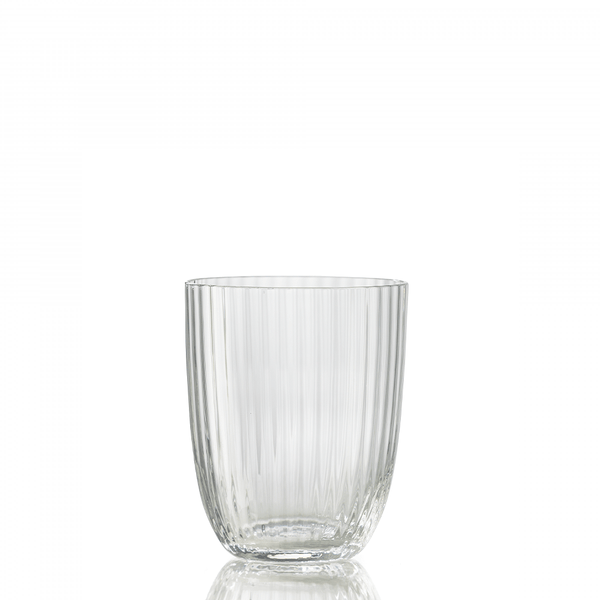 The Nason Moretti Idra Tumbler Rigadin is a clear glass with vertical ribbed lines, shown empty on a reflective surface and set against a plain white background.