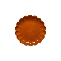 The Costa Nova Marrakesh Dinnerware Orange plate has a round, scalloped flower-like edge, a speckled pattern, and is crafted from recycled clay; it’s shown against a white background.