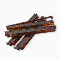 Six glossy, tortoiseshell-patterned barrette hair clips are stacked on a white background, perfect as chic Game Night Accessories or to pair with your Oh My Mahjong Mahjong Rack & Pusher Set - Tortoise Shell.