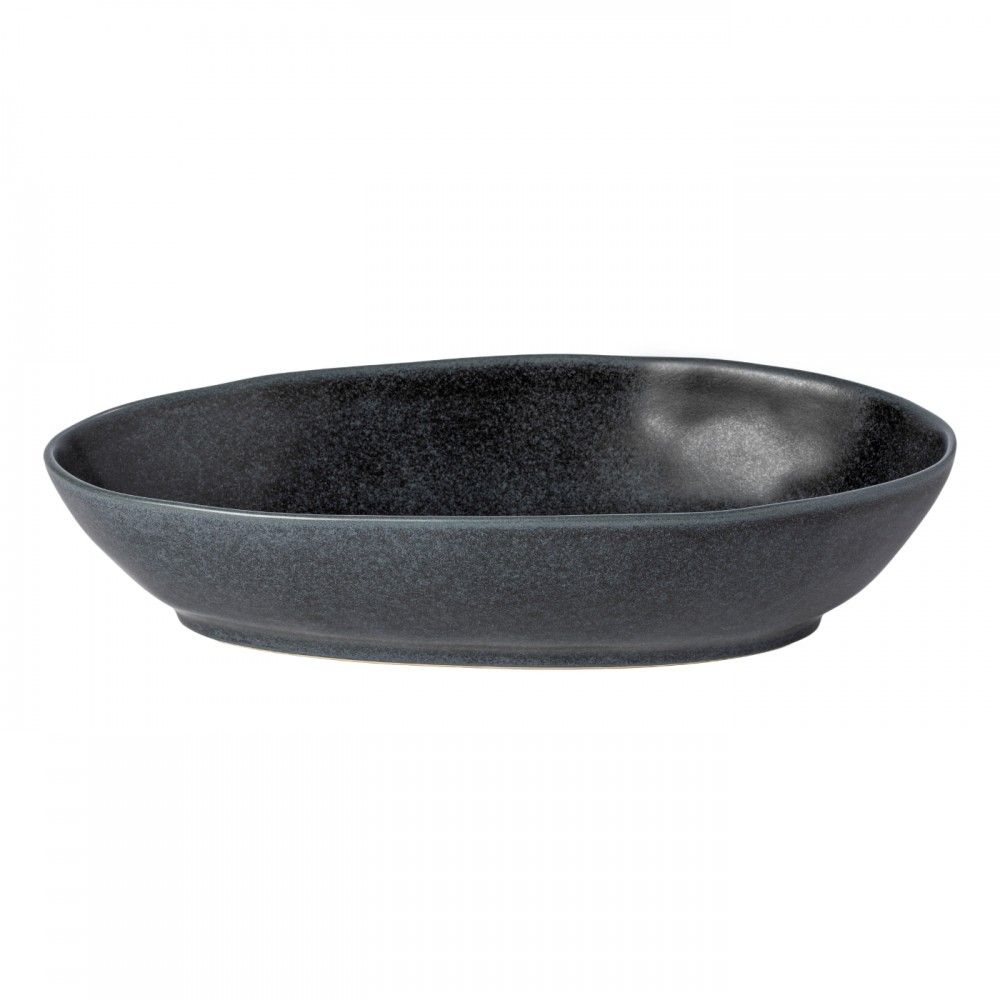 The Livia Dinnerware Matte Black bowl by Casafina/Costa Nova features a dark, oval shape with a slightly irregular rim and speckled matte finish, shown here against a plain white background.