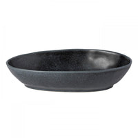 The Livia Dinnerware Matte Black bowl by Casafina/Costa Nova features a dark, oval shape with a slightly irregular rim and speckled matte finish, shown here against a plain white background.
