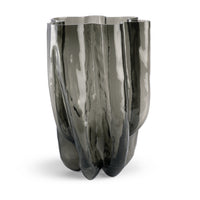The Hudson Smoke Grey Vase by FlowDecor Inc. is a tall, watertight vase made of reflective smoky gray glass, featuring an organic, uneven shape with wavy, flowing contours.