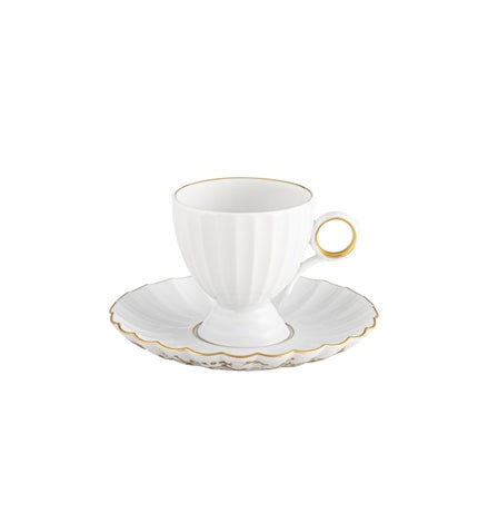 The Vista Alegre 200 Anos Dinnerware features a white porcelain teacup with a hand-painted gold rim and handle on a matching scalloped saucer edged in gold, showcasing modern elegance against a white background.