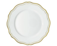 The Raynaud Polka Gold Dinnerware features a white scalloped plate with a gold rim, perfect for elevating your tableware.