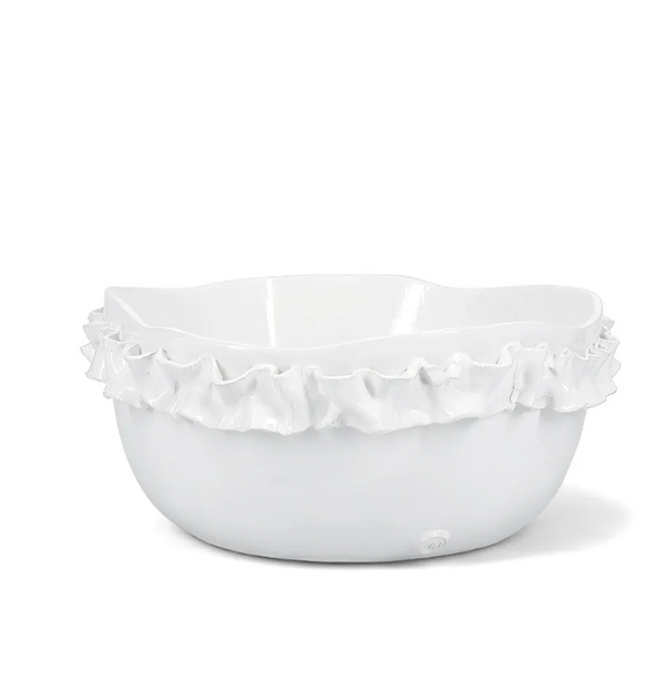 The Montes Doggett Ceramic Serveware - Bowl 682 is a white ceramic bowl featuring a ruffled, wavy rim that adds a decorative and elegant touch. Expertly crafted as artisan pottery, this high fired bowl boasts a smooth glossy finish and sits beautifully on any surface.