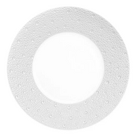 The Bernardaud Ecume Dinnerware Perle plate features a round white design with a wide, textured rim of raised dots and a smooth center—an elegant addition to any table.