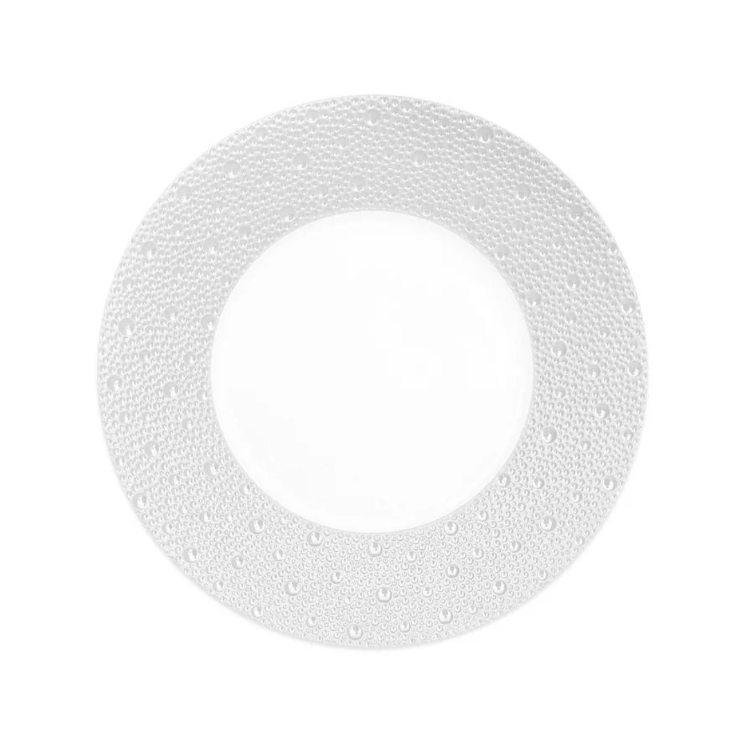 A white ceramic plate with a wide rim and raised dot texture from the Ecume Dinnerware Perle collection by Bernardaud, shown on a plain white background.