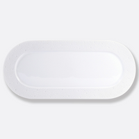 An oval-shaped Ecume White Dinnerware plate by Bernardaud, crafted from white Limoges porcelain with a smooth center and subtly textured raised rim, shown on a light gray background.