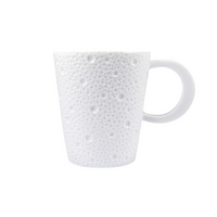 The Bernardaud Ecume White Dinnerware mug is crafted in France from white Limoges porcelain, featuring a large handle and a textured surface with raised dots and bumps, shown against a plain white background.