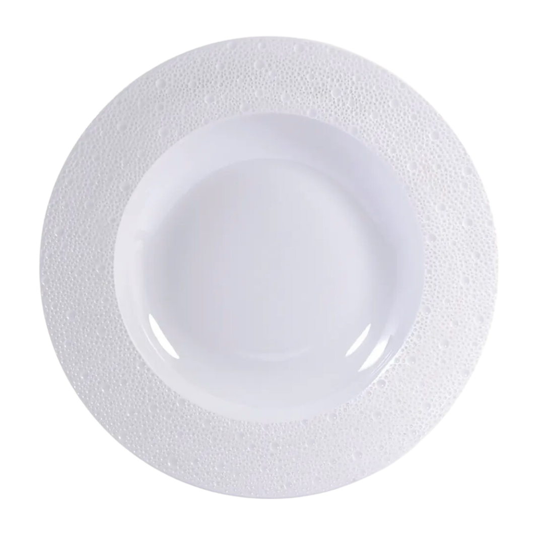 The Ecume White Dinnerware by Bernardaud is a white, round, shallow bowl with a wide rim and subtle dimpled texture, crafted from Limoges porcelain and shown from above on a plain white background.