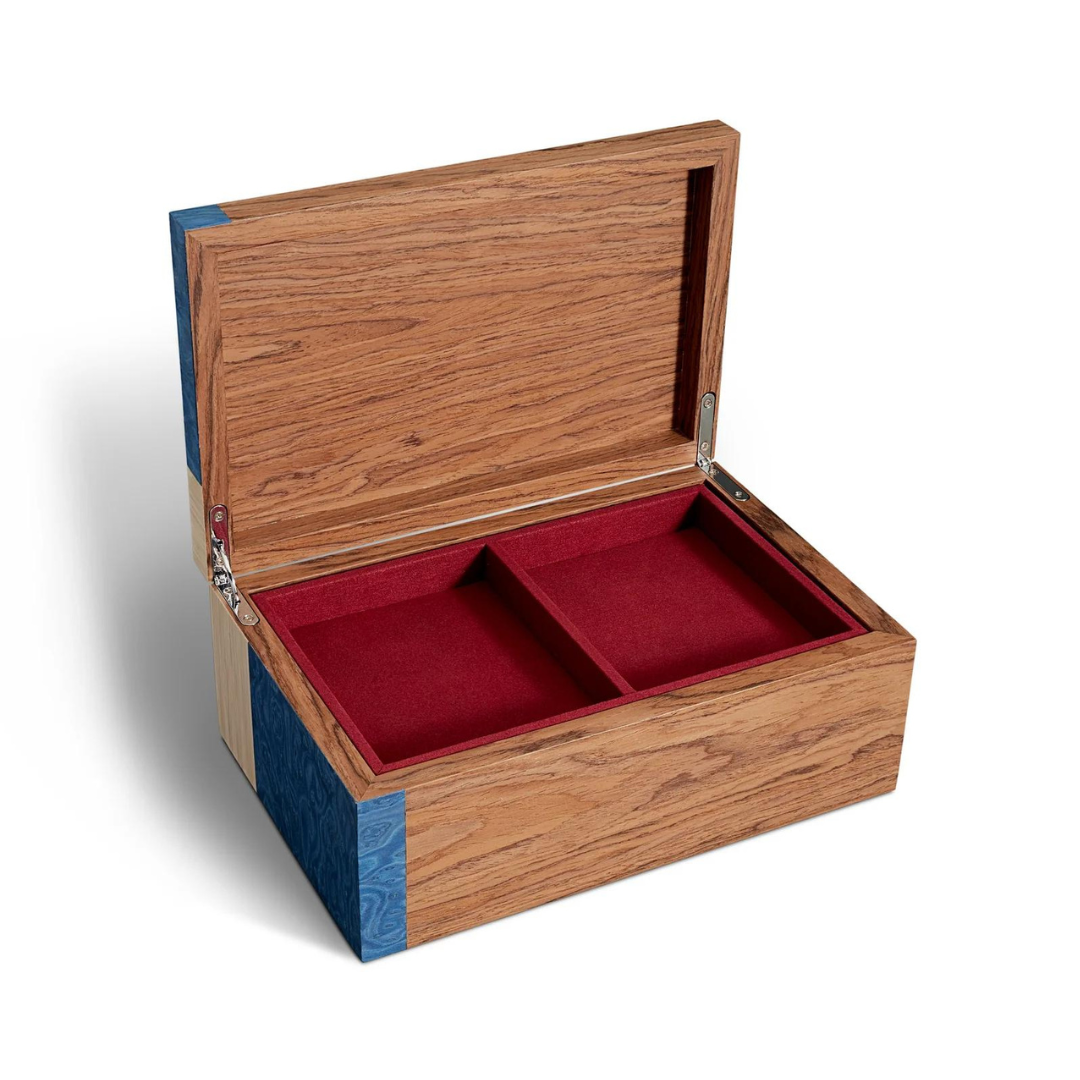 The Edgar Box by L'Objet features exotic wood with blue accents and opens to a red velvet-lined interior divided into two sections, shown against a white background.