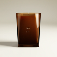 Hara (Home) candle in a square, translucent amber glass jar with a botanical fragrance.