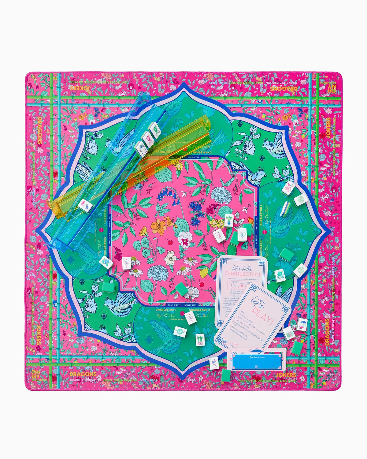 The Oh My Mahjong Rack & Pusher Set - Multi features vibrant pink Mahjong tiles with floral and bird designs, two clear American-style racks, instruction cards, pushers, and a decorative mat—all from Oh My Mahjong.