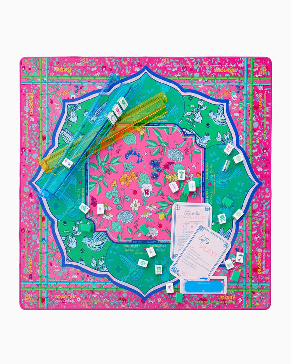 The Oh My Mahjong Rack & Pusher Set - Multi features vibrant pink Mahjong tiles with floral and bird designs, two clear American-style racks, instruction cards, pushers, and a decorative mat—all from Oh My Mahjong.
