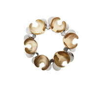 Inspired by Kim Seybert’s Enigma Napkin Rings Gold & Silver Set of 4, this circular bracelet features alternating gold and silver crescents, evoking luxurious table decor with a striking contrast against a white background.