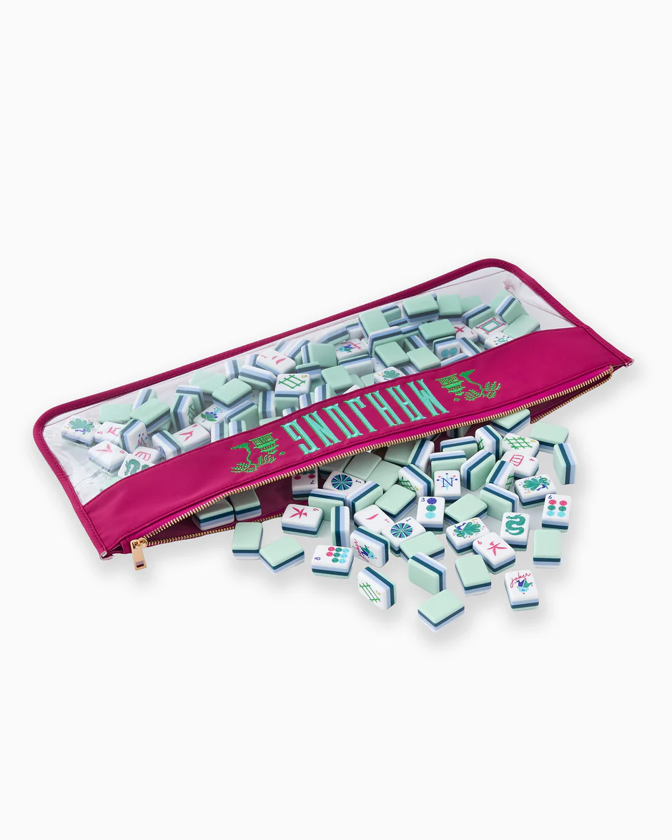 The Oh My Mahjong Mahjong Tile Bags in magenta feature a zippered pouch with a clear panel, showcasing green-edged tiles with unique symbols—serving as a stylish organizer for your mahjong set.