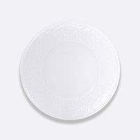 The Bernardaud Louvre Dinnerware is a round, white ceramic plate featuring a subtle Renaissance-inspired floral rim, shown on a plain light gray background.