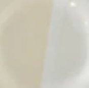 A close-up image shows two adjacent curved shapes, one beige and one off-white, with a soft, blurry look—suggesting artisan craftsmanship of Low Handmade Serving Bowls by Alex Marshall Studios.