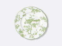 Bernardaud’s Albertine Dinnerware is a white ceramic plate with scalloped edges, adorned with a green floral and bird motif inspired by toiles de Jouy, featuring a perched bird among flowers and leaves on the rim and center.