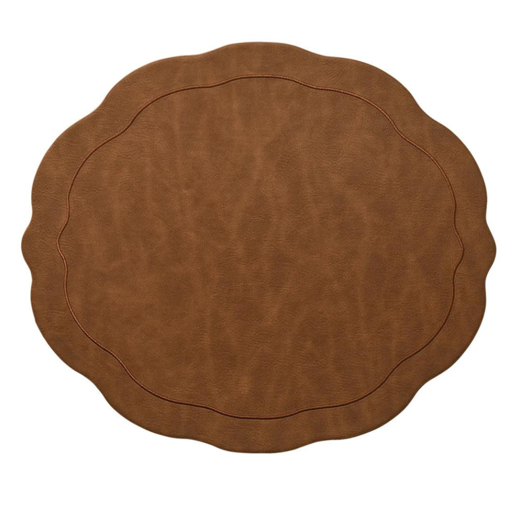 The Kim Seybert Tailored Placemat Brown Set of 4 features a wavy, scalloped design in matte faux leather with a subtle stitched border, shown on a white background.