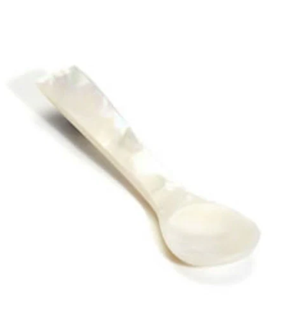 The Cora Pearl Spoon by Blue Pheasant features a white, iridescent mother-of-pearl finish with a rounded bowl and slightly curved handle. Set against a white background. Hand wash only; not dishwasher safe.
