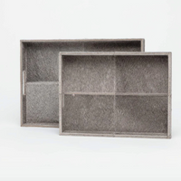 Two Made Goods Renard Rectangle Hide Grey Trays, each with four compartments and textured gray leather, are displayed on a plain white background. One tray is slightly in front of and overlapping the other.