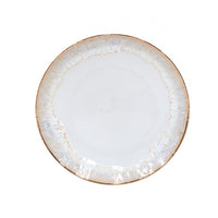 The Taormina Dinnerware White & Gold plate by Casafina/Costa Nova features a round white ceramic design with a hand-painted, irregular 18-karat gold rim and an opalescent sheen, shown against a plain white background.