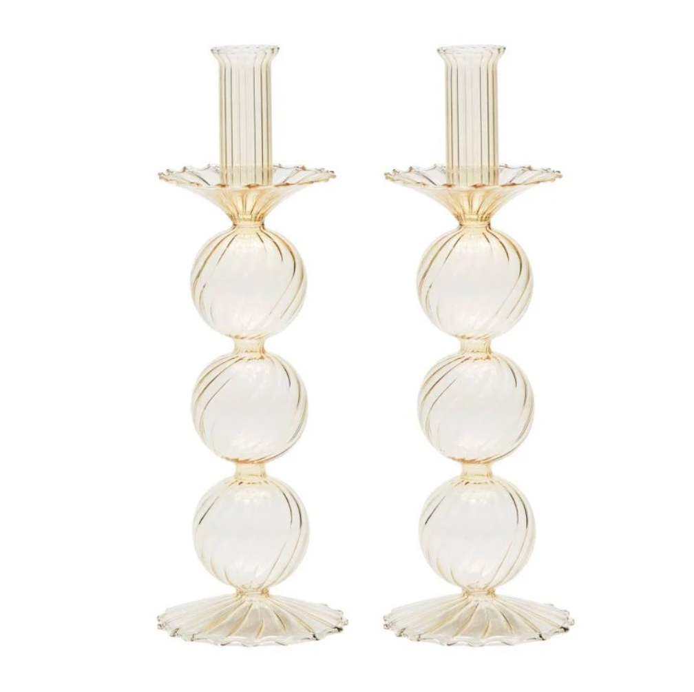 The Kim Seybert Iris Candlestick Holder Set of 2 features elegant hand-blown glass, each with three stacked ribbed spheres and scalloped base and top in a light beige or champagne hue.