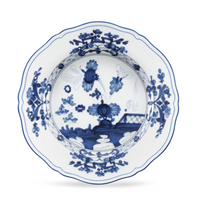 Ginori 1735 Oriente Italiano Indaco white porcelain bowl with a scalloped edge, decorated with an Antico Doccia blue floral and landscape motif.