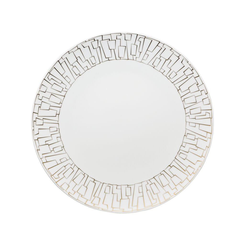 The Rosenthal Tac Skin Gold Dinnerware features a round white plate with a durable glaze and an elegant gold geometric rim, showcasing interconnected angular shapes on a sleek, plain background.