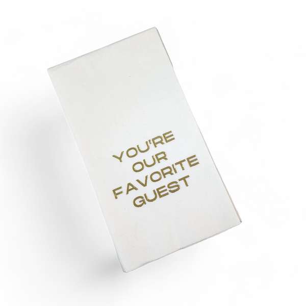 The Print Appeal Guest Towel Pack- Gold - You're Our Favorite Guest features white rectangular towels with gold embossed text, ideal for adding a thoughtful touch to your guest bathroom when displayed in an acrylic holder.