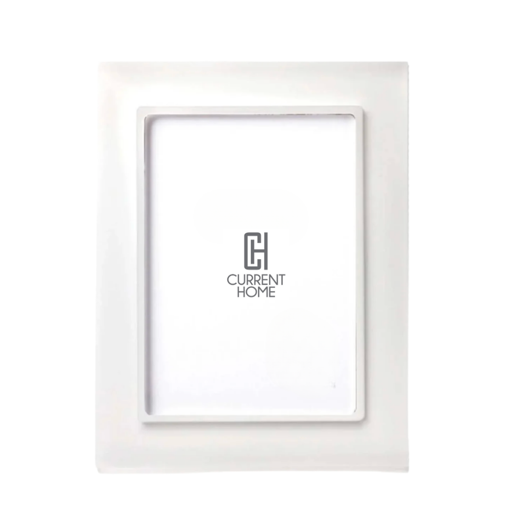 The Prisma Frame Snow White by Bella Moulding features a raised border, white insert with the Current Home logo, and UV-filtering glass for added photo protection.