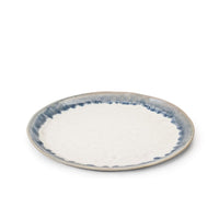 A round ceramic plate from the Simon Pearce Burlington Dinnerware Pool collection, featuring a white center and blue glazed, watercolor-style edge, is displayed against a plain white background.