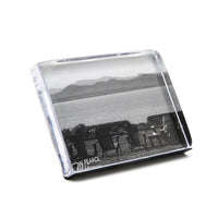 Glass paperweight with a black and white landscape print on a white background
