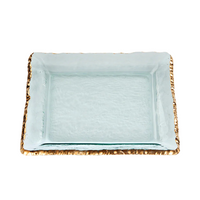 The Annieglass Edgey Square Platter Gold 12" is a handmade glass platter with textured, raised edges, a 24kt gold border, and a clear yet slightly frosted look for an elegant touch.