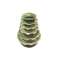 A set of five green ceramic bowls with wavy, uneven rims, stacked inside each other and photographed from above against a white background. Part of the Musas Collection by CDMX / MASA TALLER, these bowls are inspired by organic forms reminiscent of the Chavela Vase - Laguna.