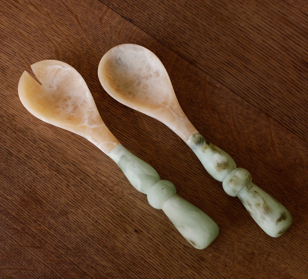 The Beatriz Ball Resin Giada Salad Server Set - Jade Swirl features a fork and spoon with jade swirl handles and marble-style heads, shown side by side on wood—perfect for serving in style.
