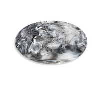 The Nashi Home Swirl Resin Classic Round Chopping Board, made from durable shatterproof resin with a marbled black, white, and gray pattern, is displayed on a white background.