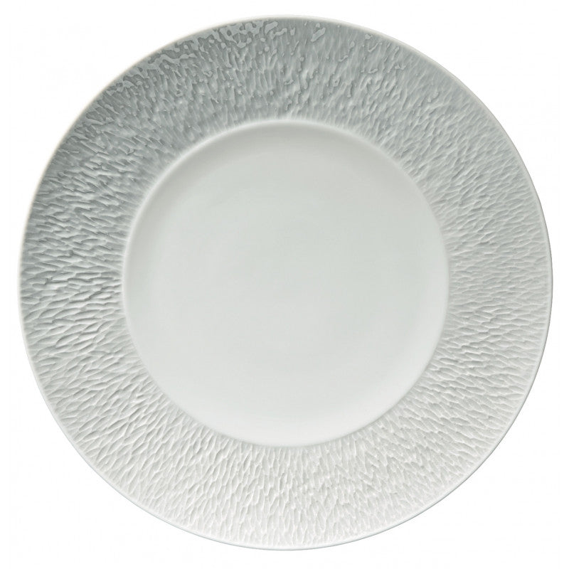 The Raynaud Mineral Dinnerware Glazed White plate, inspired by French design, displays a textured patterned rim and smooth center, shown from above on a plain background.