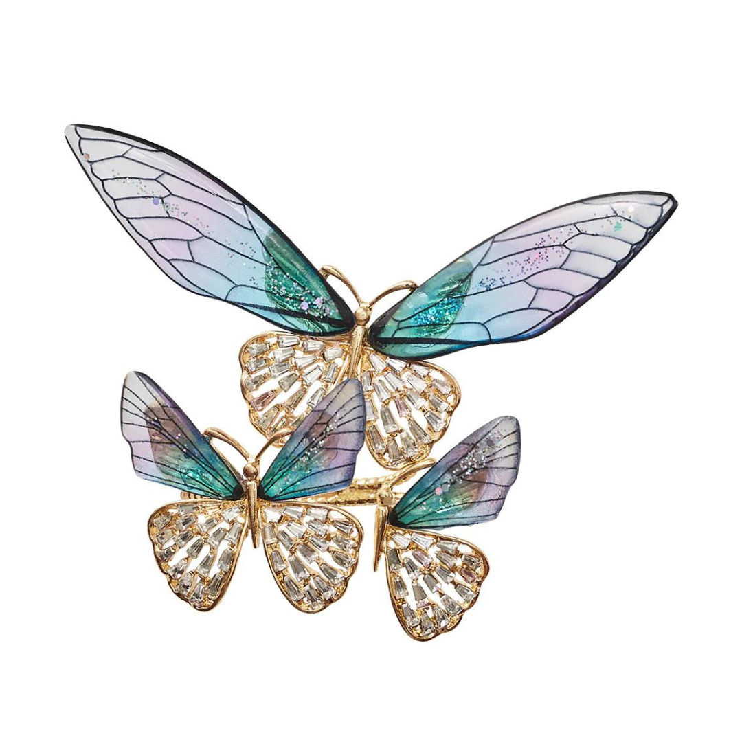 The Kim Seybert Flutter Napkin Ring Set of 4 in Lilac & Periwinkle features three butterflies with pastel, translucent wings and gold bodies, clustered together to add sparkling elegance to your table.