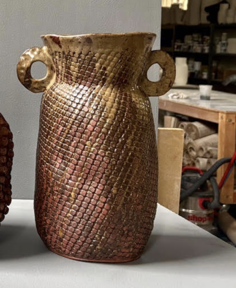 Reddish-brown handcrafted Amphora Grid Vase - Red Iron with a patterned exterior and two side handles.